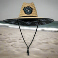 Black surfboard with a straw bag on a white background